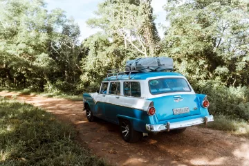 Oldtimer fährt mit Gepäck auf dem Dach durch Kuba