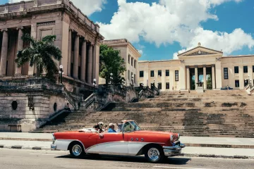 Ein Oldtimer steht vor der Universität Havannas