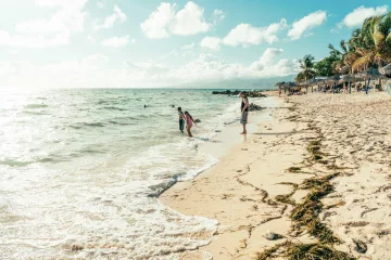 Menschen entspannen an einem weißen Strand in Kuba